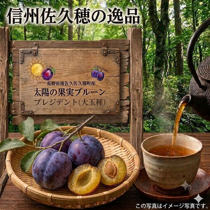 静かな森の木製のテーブルの上に、濃い紫色の「太陽の果実プルーン プレジデント（大玉種）」が入ったかごが置かれており、そのうちの1つは切り開かれて、ジューシーな果肉がのぞいています。かごの横にあるカップには、ティーポットからお茶が注がれています。 その背後には、日本語の文字とプラムのイラストで飾られた素朴な木製の看板が掲げられており、この上質なプルーンの「DS予約販売」が告知されている。発送は9月上旬頃から2週間程度にわたり行われる予定であると記されている。.